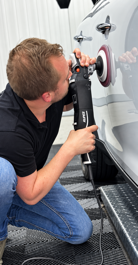 Professionele machinale lakpolijsting onder detailingverlichting